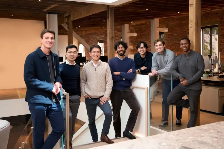 Seven diverse men standing together in a modern office.